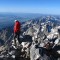 A climber on the summit of the Grand Teton in Grand Teton National Park surveys the Jackson Hole valley below.