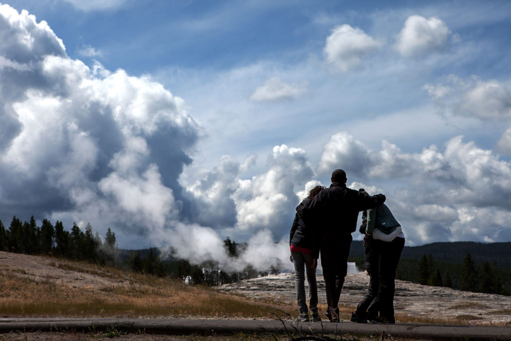 President Barack Obama awaits the eruption of Old Faithful with First Lady Micelle Obama and daughters Sasha and Malia during a 2009 visit to Yellowstone National Park.