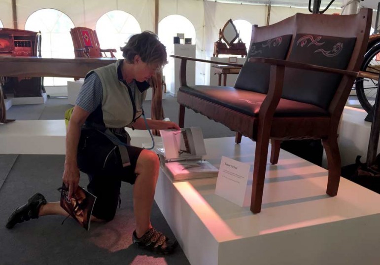 Western design enthusiast Peggy Ruble examines, Teton Settee, created by John Gallis of Norseman Designs West.