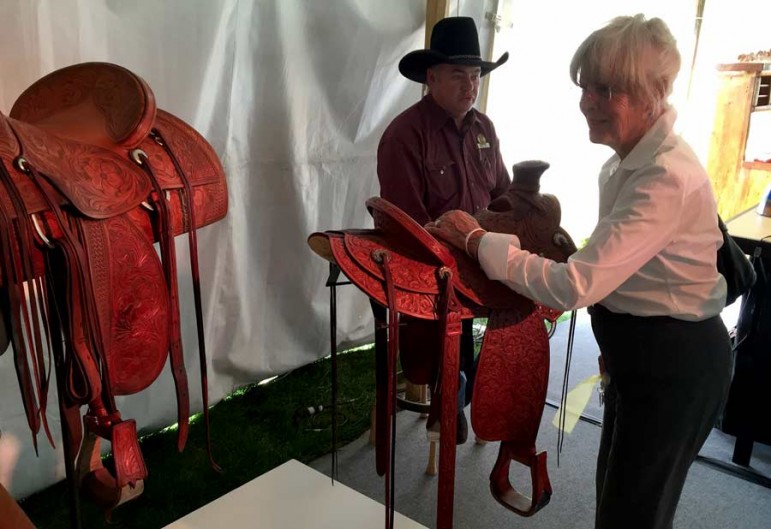 Western design enthusiast Ann Simpson chats with saddle maker Keith Seidel on Wednesday at the By Western Hands design exhibition in Cody, Wyo.