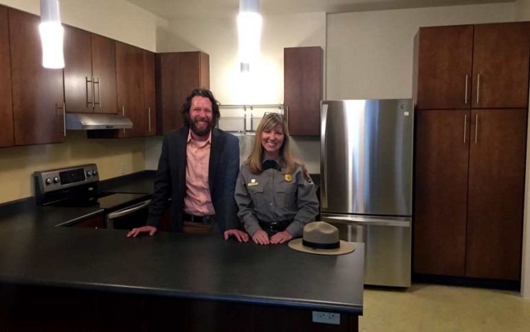 Dylan Hoffman, director of environmental affairs in Yellowstone for Xanterra Parks and Resorts, stands in the kitchen of a new employee housing unit near Old Faithful. He is joined by Julena Campbell, a spokeswoman for Yellowstone National Park.