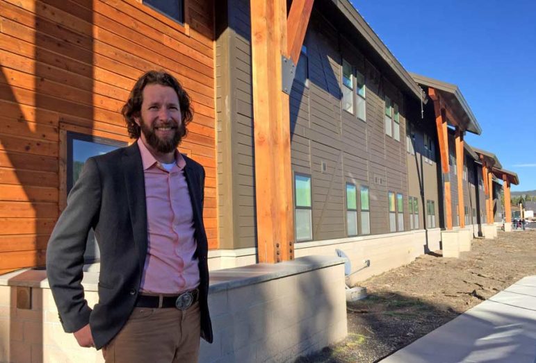 Dylan Hoffman, director of environmental affairs in Yellowstone for Xanterra Parks and Resorts, stands near the entrance to Paintbrush Lodge, a newly completed employee dormitory in Yellowstone National Park.