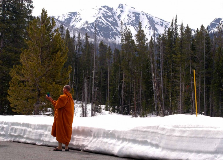A Buddhist monk from Thailand takes photographs at Sylvan Lake on Friday in Yellowstone National Park.