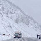 Two motorists pause at a pull-out atop Sylvan Pass to discuss snowy road conditions Tuesday in Yellowstone National Park.