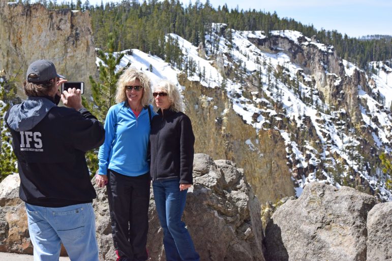 Jacob Baisley, who recently quit his job and sold his house to travel to national parks, snaps a photo May 4 of two Yellowstone National Park visitors at Artist Point.