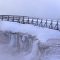 Visitors traverse the snow-covered boardwalk along Excelsior Geyser Crater in Yellowstone National Park. Private businesses have pitched in to keep the park open during the partial government shutdown .