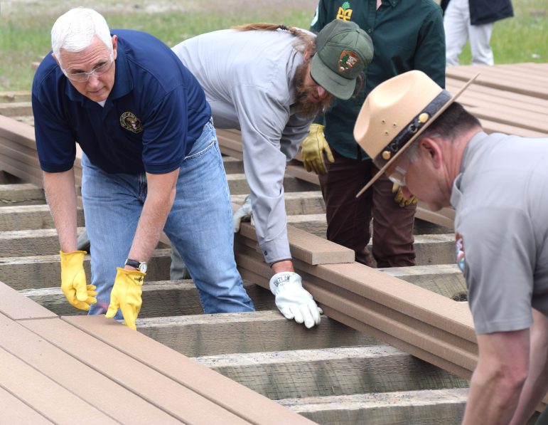Then Vice President Mike Pence joins Yellowstone Superintendent Cam Sholly in a project to install new boardwalks near Old Faithful in 2019. Yellowstone Gate photo by Ruffin Prevost.